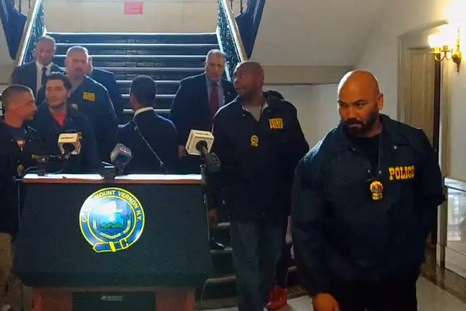 Detective Camilo Antonini (right foreground) leaving a press conference held by Mount Vernon’s former mayor and police commissioner.